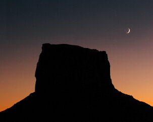 Moon over Monument A crescent moon accompanies an ancient monument. Monument Valley, Navaho Nation 4 November 2005