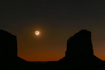 Moon between Monuments There is enough earthshine to illuminate the dark side of the moon. Monument Valley, Navaho Nation 4 November 2005