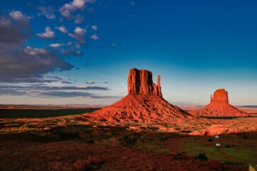 Mitten Buttes at Sunset West Mitten and East Mitten Buttes of Monument Valley are bathed in late afternoon lighting, the geology further reddened by the beauty light of sunset....