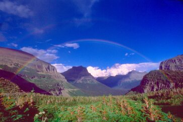 Both Ends of the Rainbow The late afternoon breeze pushed cumulus clouds through the mountain pass, some of them containing excess water. Dark smears drained the rain from them as they...