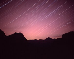 Going to the Sun The distinctive three-pointed peak of Going-To-The-Sun Mountain shows left of center in this view from Logan Pass. The trails of the stars arc gently up to the...