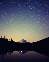 Frog Lake Mt Hood stands silently in the late summer twilight as lights blaze at the ski area that is open all year round. The waters of this lake are calm enough to...