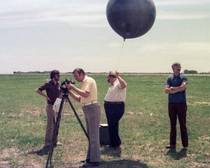 19770500 Balloon Launch T10-26 Preparing to measure the winds aloft. A transit telescope aims and follows the balloon as it rises and drifts with the wind.