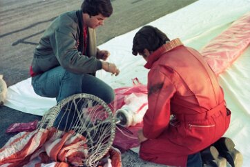 19770500 Balloon Launch T11-11 The top of a parachute is attached to the bottom of the balloon.