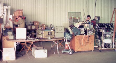 19770500 Balloon Launch T8-15 Our field lab set up in the airplane hangar. at right is the CRISIS instrument ready for final assembly by Chuck Gilman. Dr Waddington is on the left unpacking...