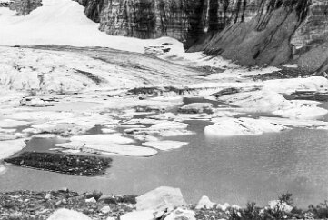 19700800-GrinnellGlacierHike-4 At the edge of Grinnell Glacier, ice floes float on the surface of the melt lake (Grinnell Lake).