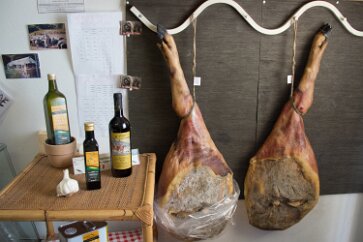 Tuscany-Siena-113 A common sight here in food shops: olive oil, garlic, and ham legs.