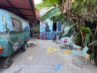 IMG_7259 The courtyard entrance. One of the hostel rooms is the camper trailer parked at the left.